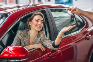 woman-sitting-red-car-receiving-keys
